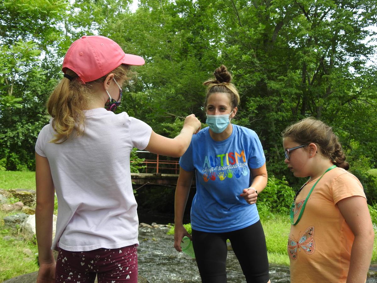 A child participating in Exploring Nature shows a finding to her teacher