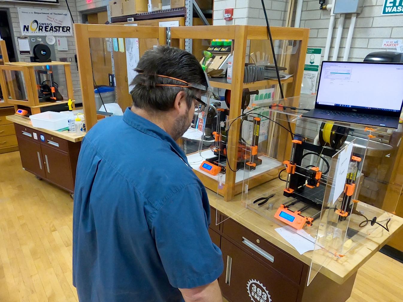 Dan Tryon manufactures face shields on a 3D printer in a Park Hall technology lab