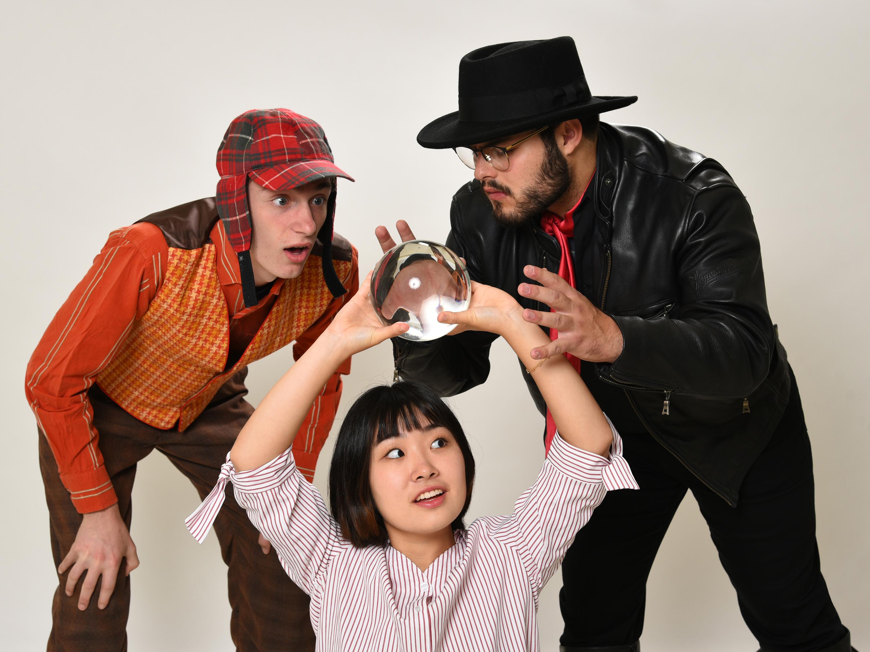 Rehearsal image of performers trying to discern the future via a crystal ball