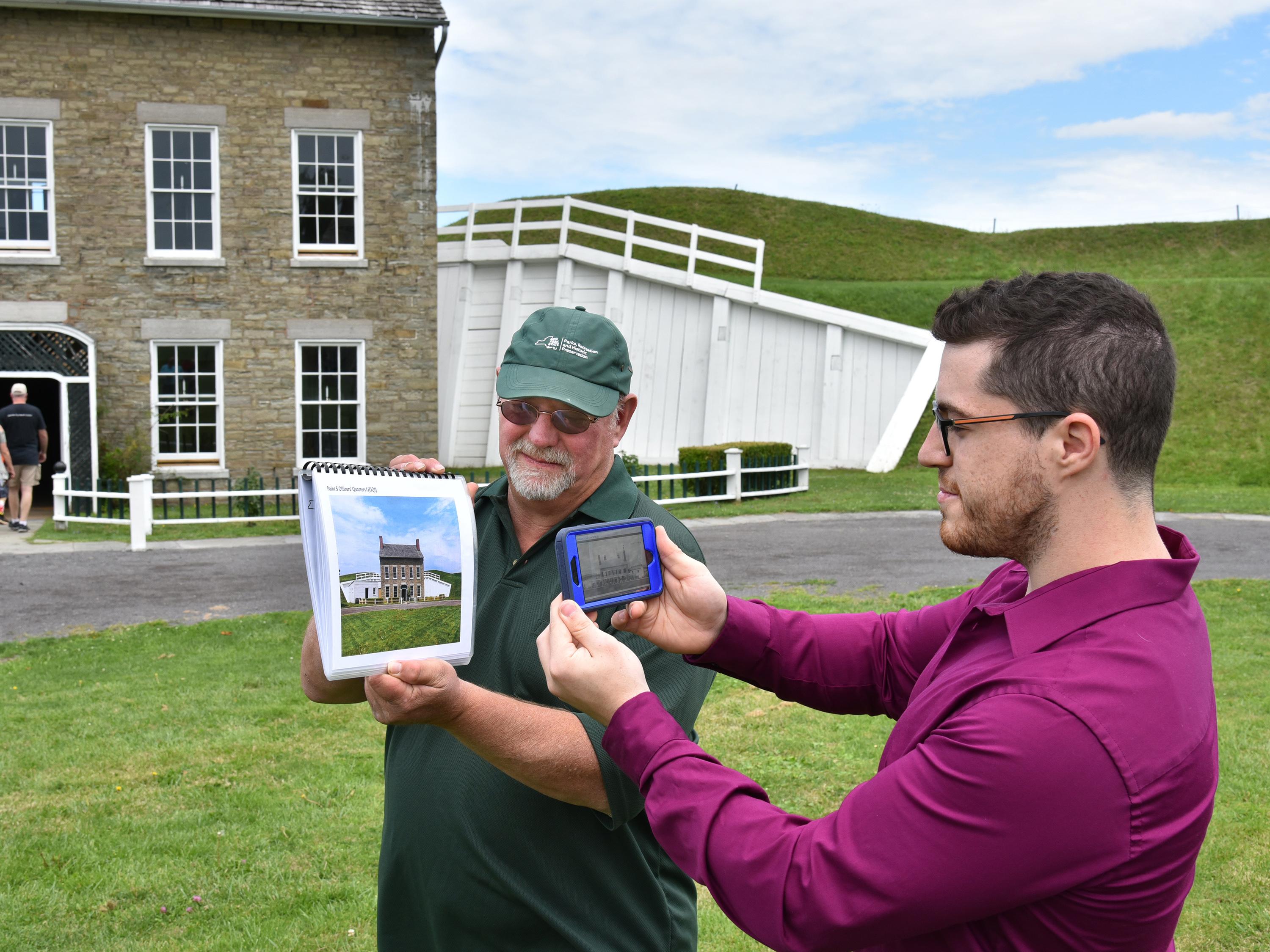 Fort Ontario's Paul Lear and SUNY Oswego graduate student Theo Johnson demonstrate an app that uses historical photos as reference points