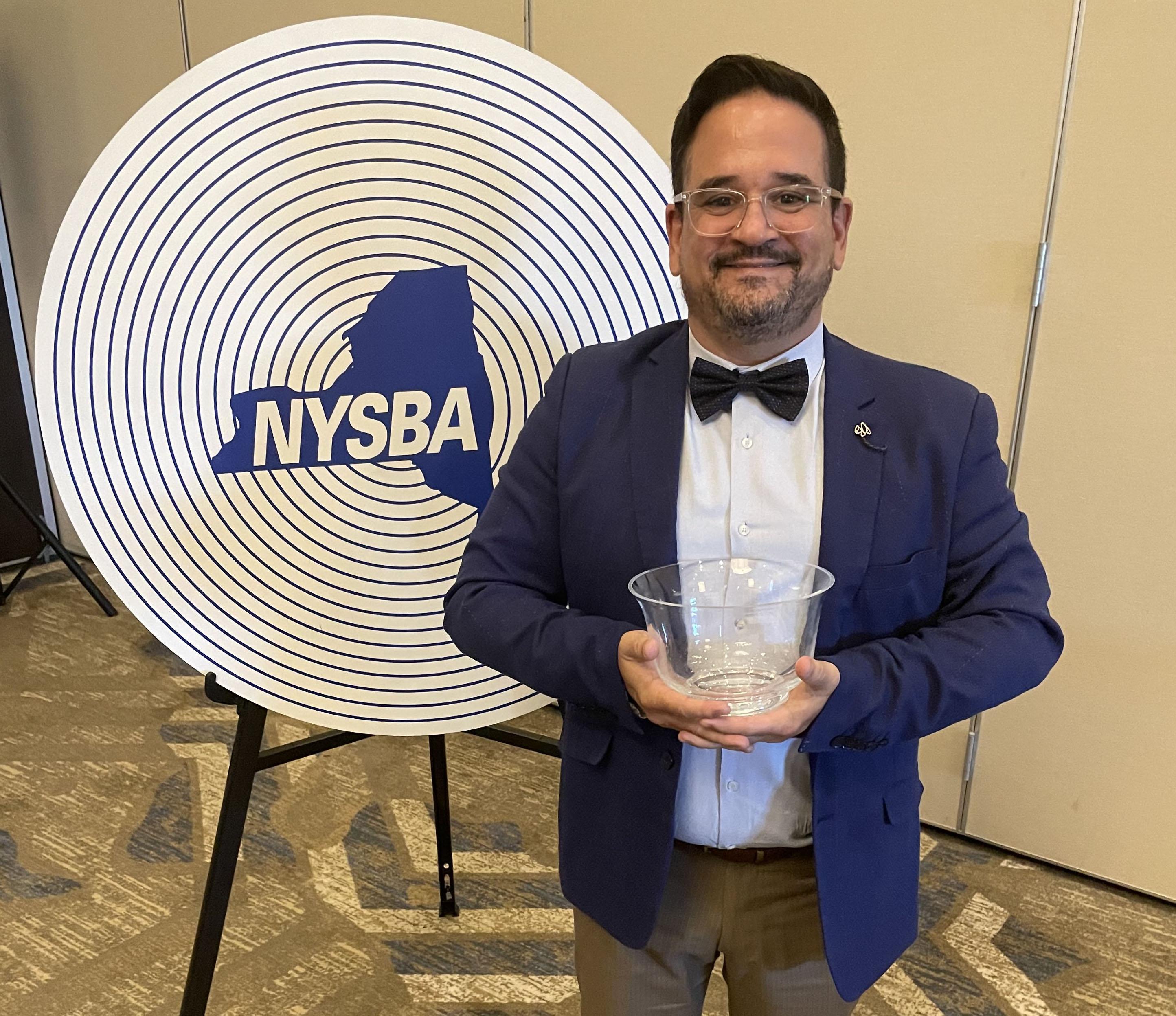 Francisco Suarez, associate professor in the communications department, poses with his trophy at the New York State Broadcasting Association awards ceremony.