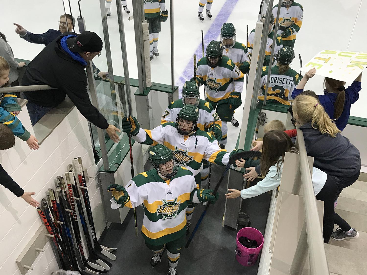 Women's hockey players high-five fans