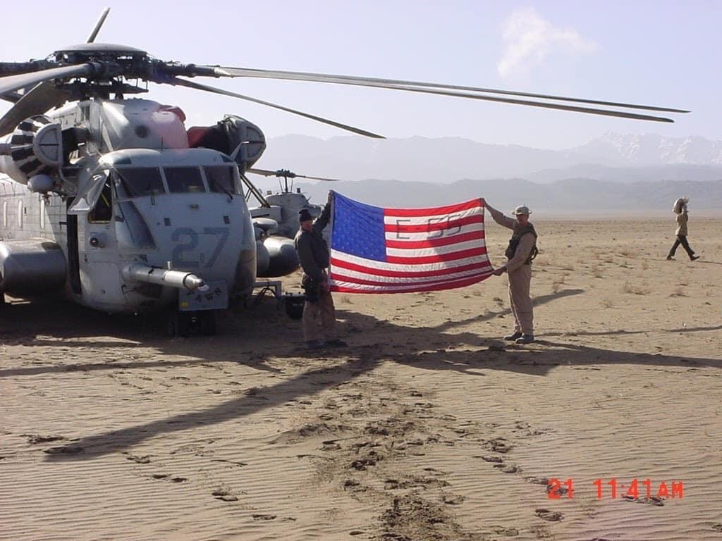 Dan Feliciano another soldier hold up the FDNY Engine 55 flag in Afghanistan.