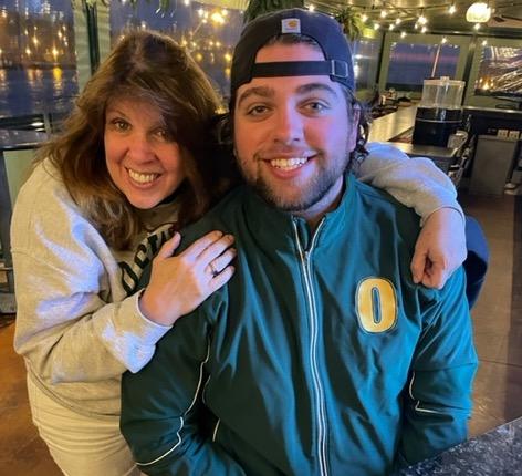 Annie and Ryan at restaurant in SUNY Oswego gear