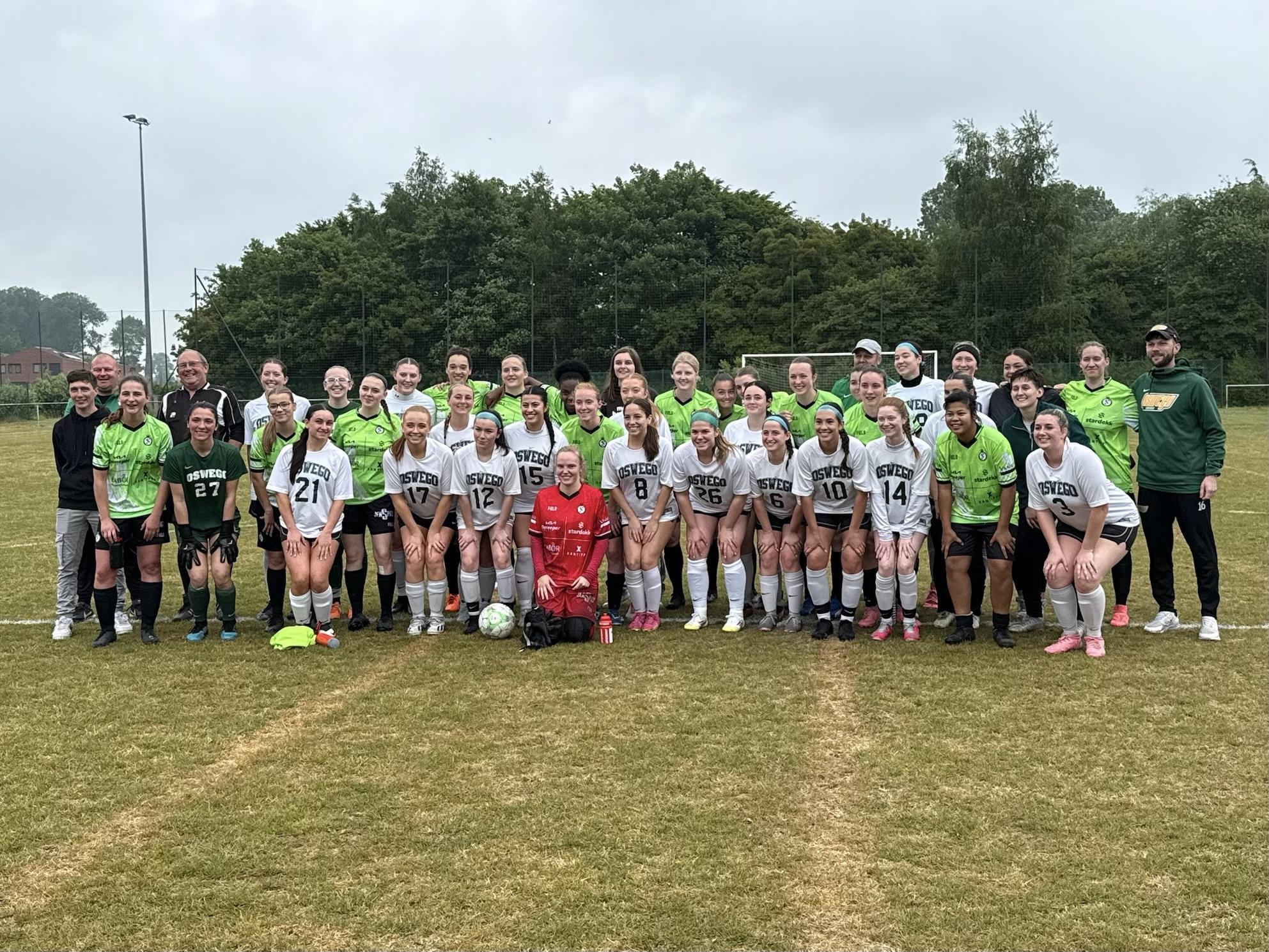 SUNY Oswego's women's soccer team and guests stand with their opponents on their trip to Europe.