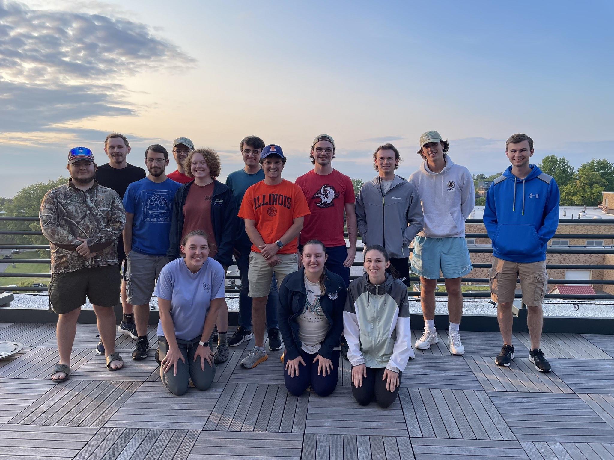 The chasers pose in front of a sunset for a picture after returning to Oswego.