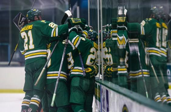 ACHA hockeys players in green jerseys with white and gold accents