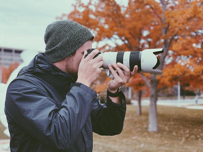 Kyle Hurley taking a photograph for the Oswego Photo Showcase project.