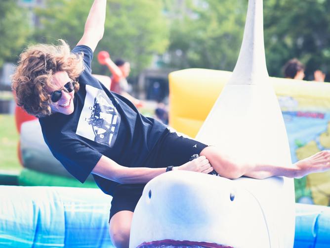 A student attempts to ride an inflatable shark at a previous year's LakerFest