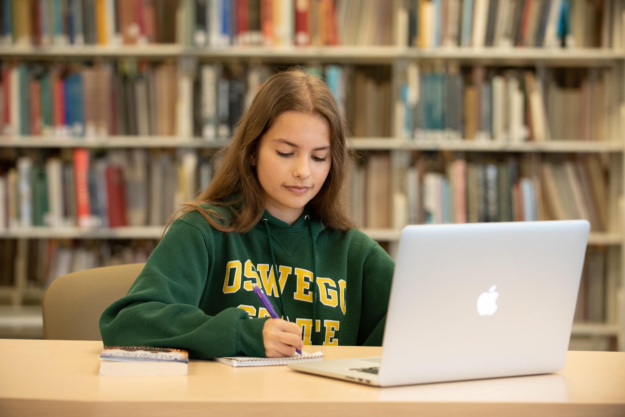 Student on a laptop in Penfield Library