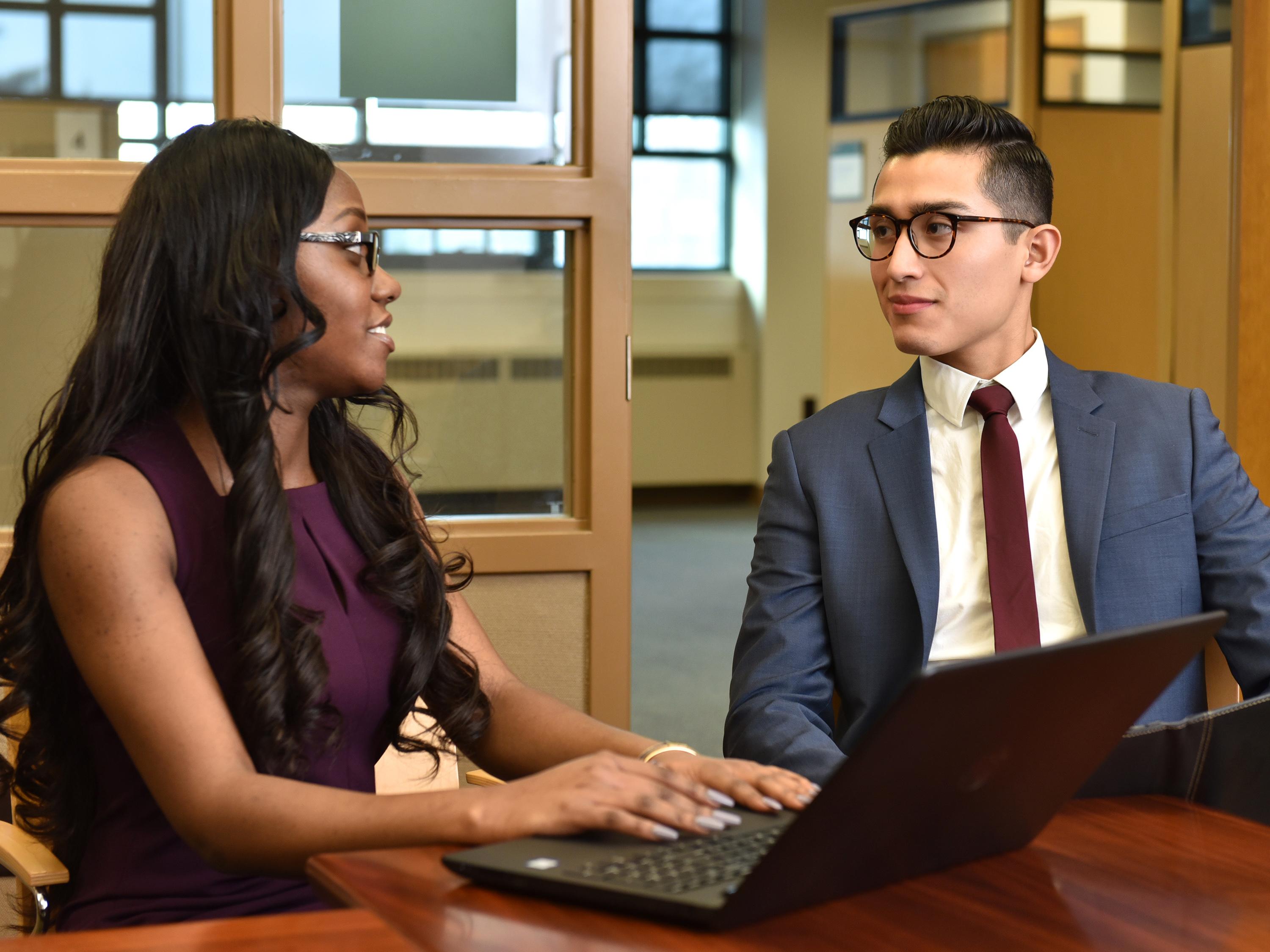 Students having a discussion over laptop computers