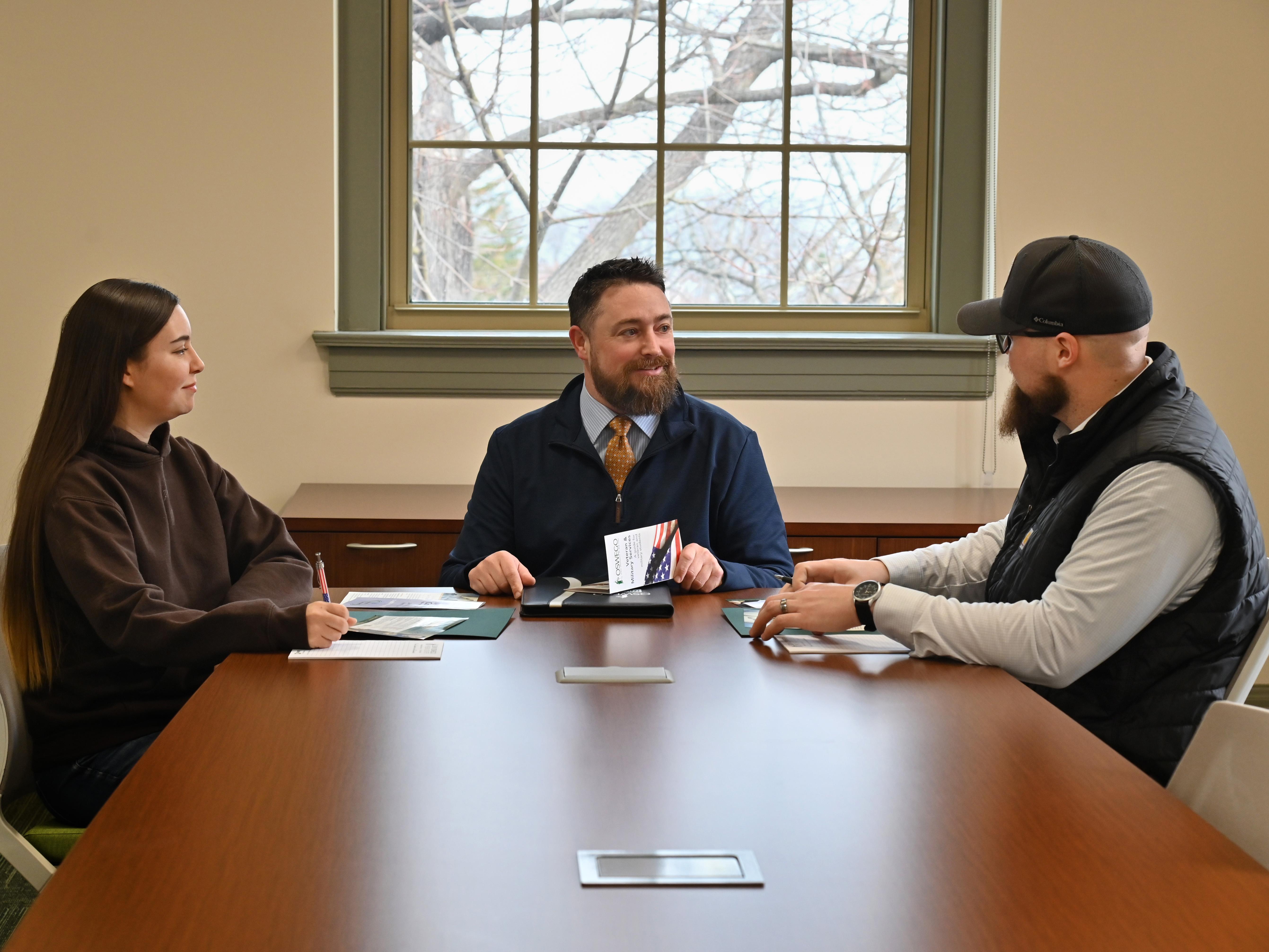 Ken Cisson meets with two students who came to SUNY Oswego after serving in the U.S. Air Force
