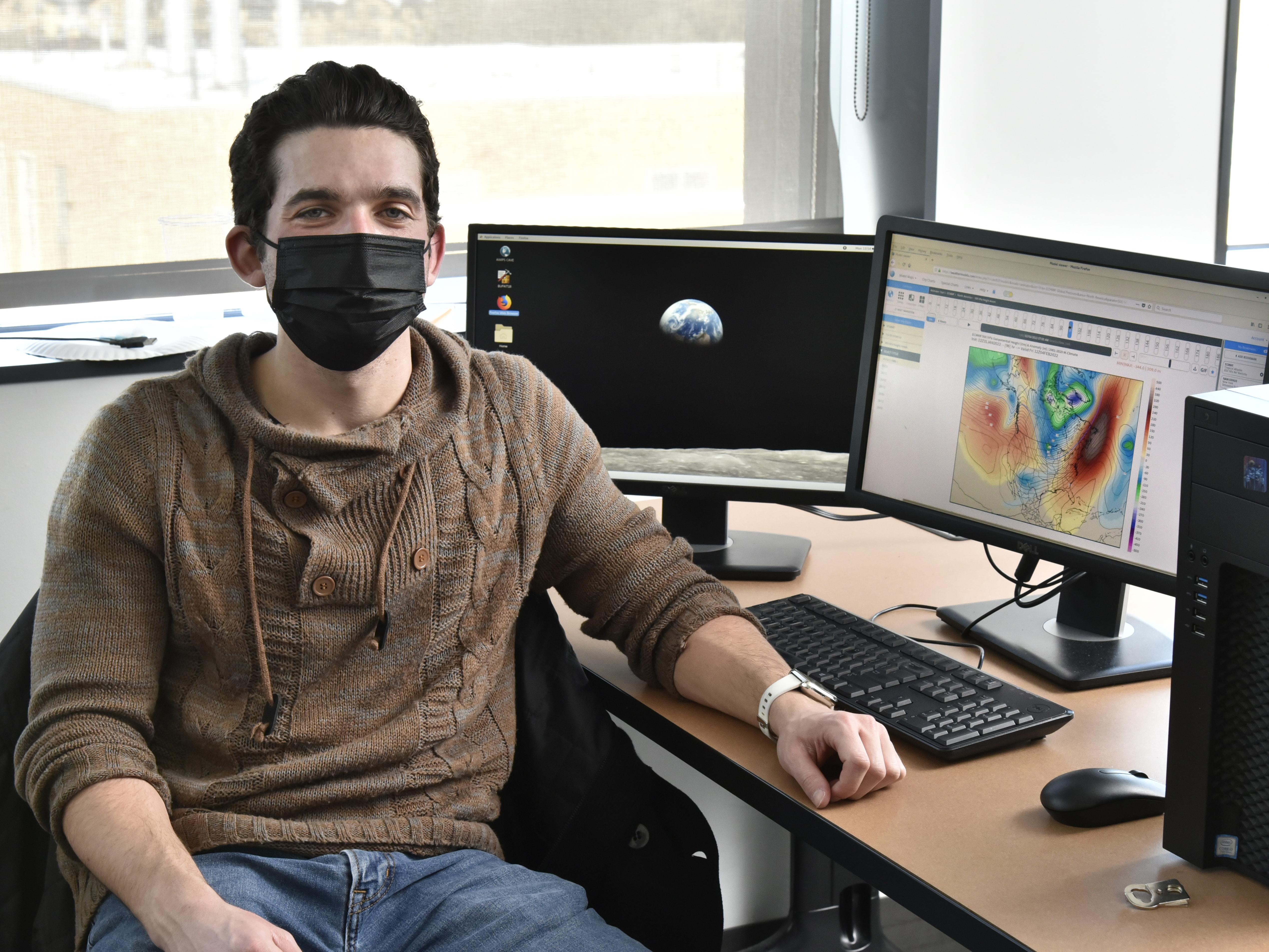 Adam Nahar working with weather modeling software in a meteorology lab