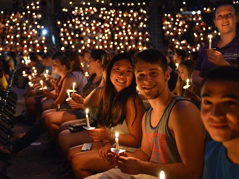 Students with lit candles at the Opening Torchlight Ceremony