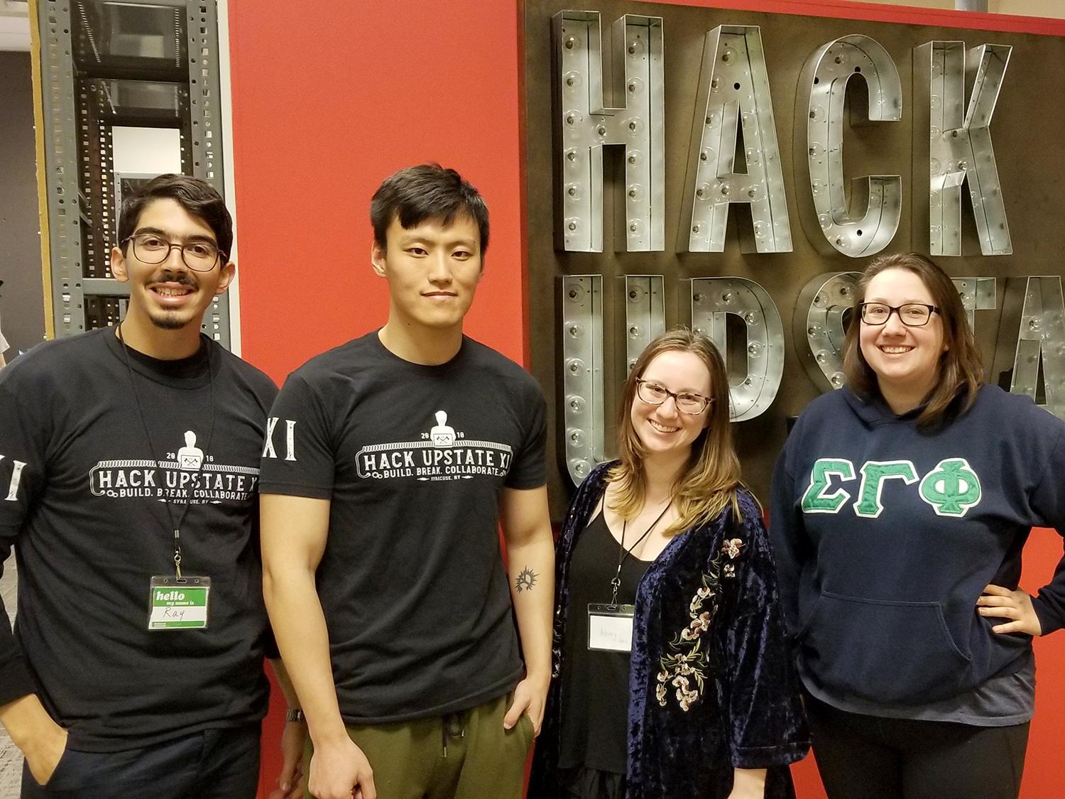 Student stand in front of the Hack Upstate sign