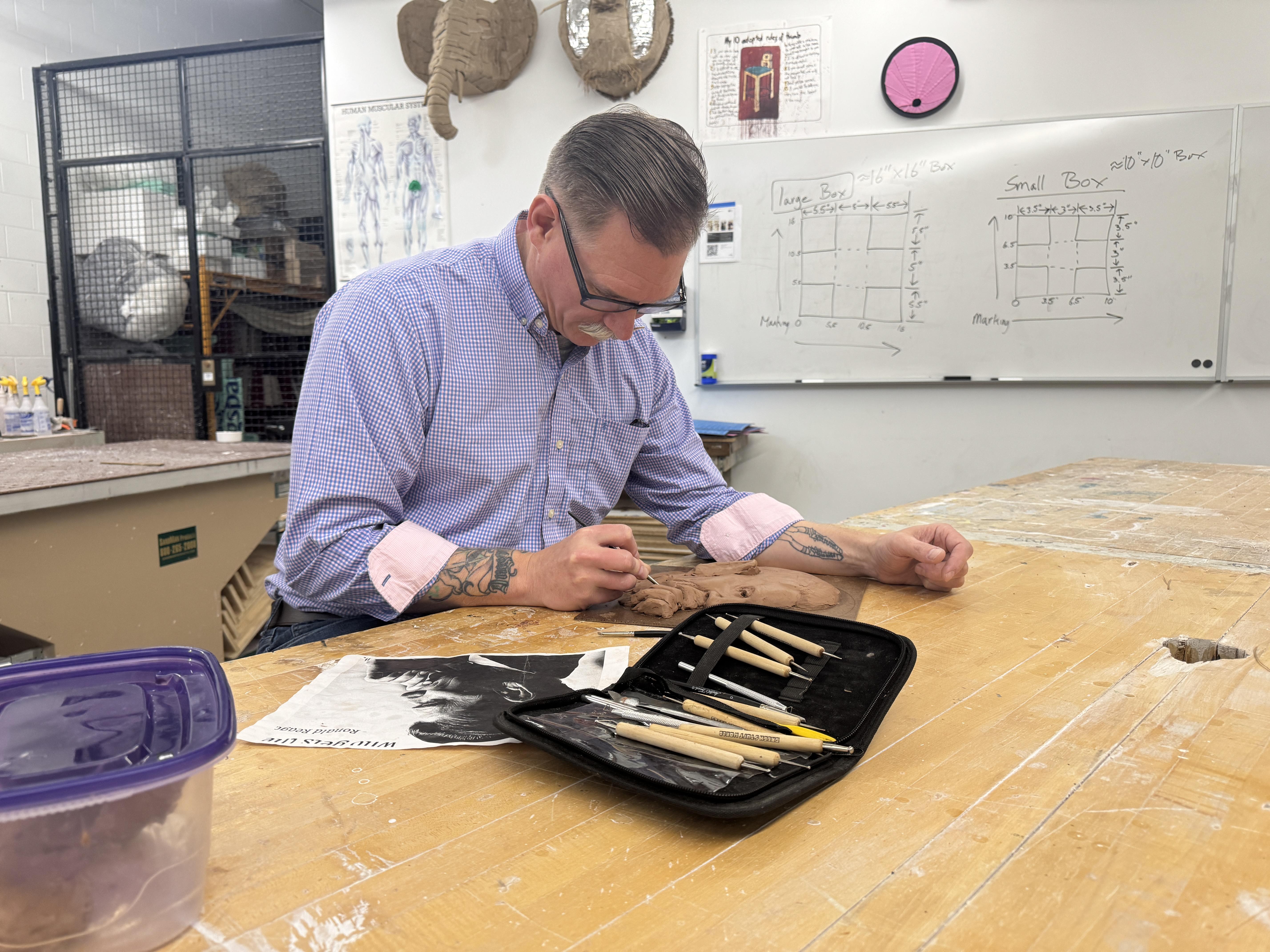 student working with clay in a studio art room