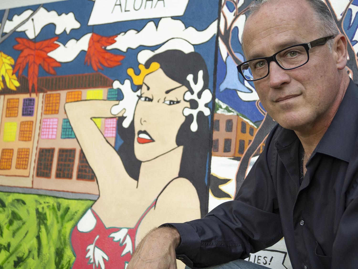 Ron Throop with a painting on Roy Lichtenstein's time in Oswego
