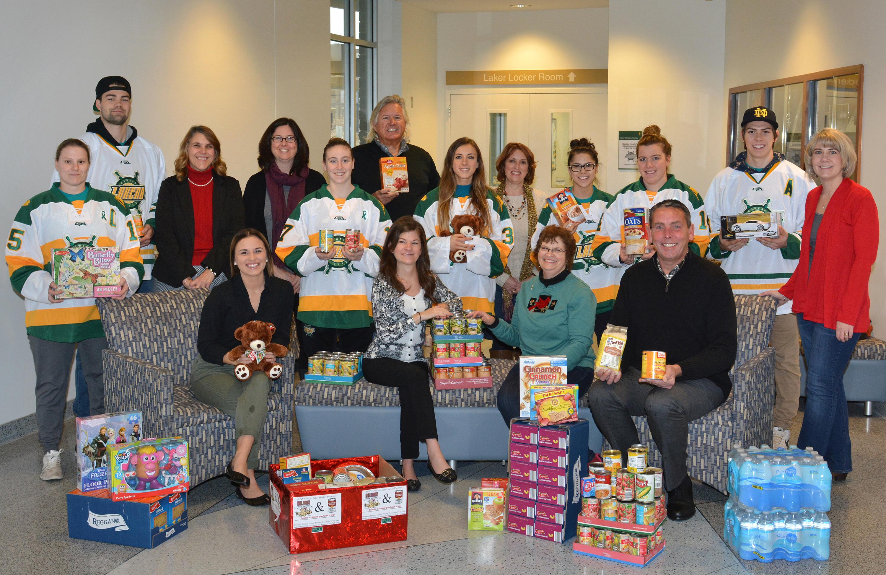 Hockey players, Oswego employees, and representatives of United Way and Human Concerns Center with food and toys