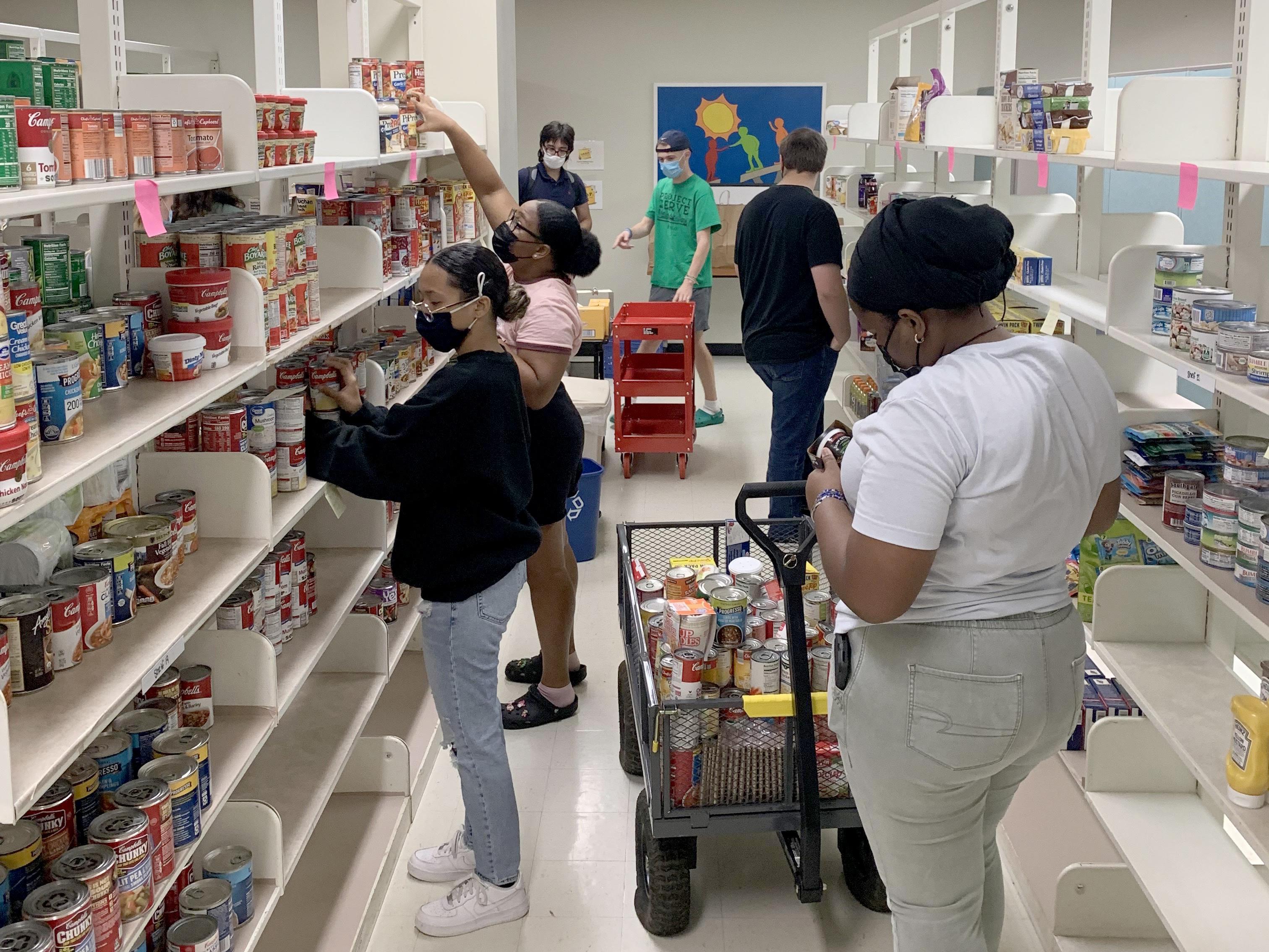 Student volunteers help stock shelves for the SHOP food pantry