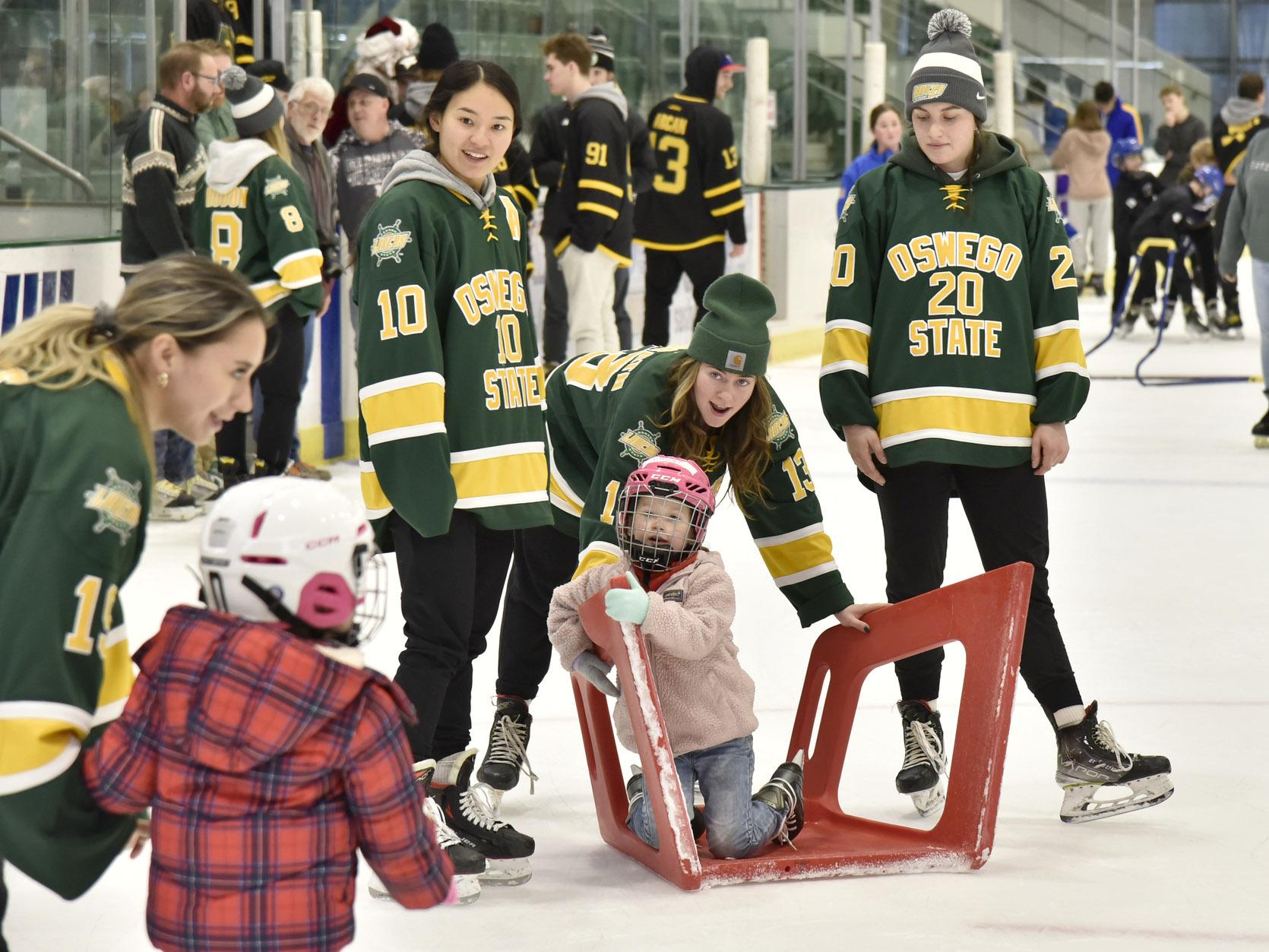 Laker women's hockey players have fun with kids during holiday skate