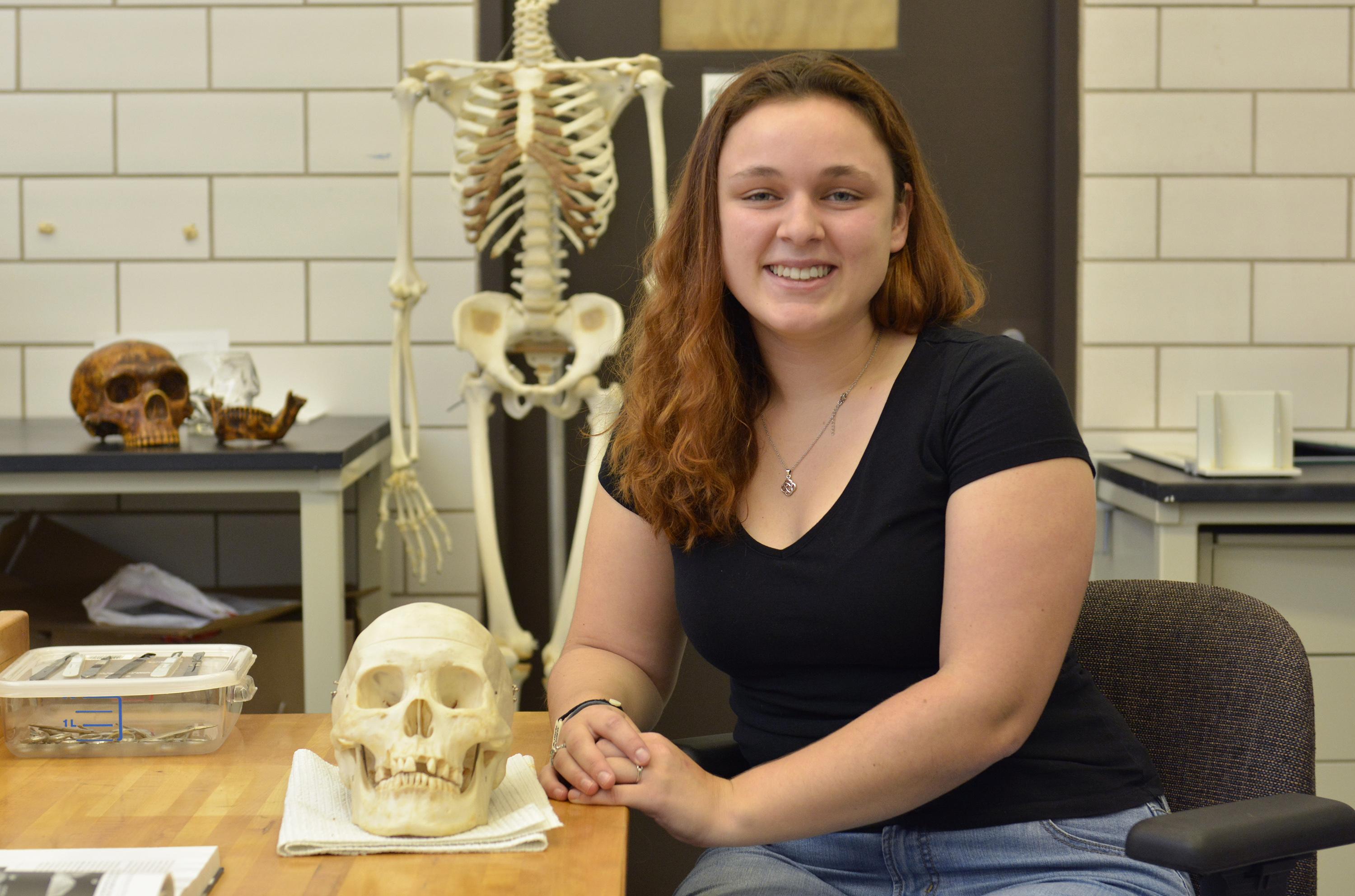 Hannah Kruse with a skull in a forensic lab