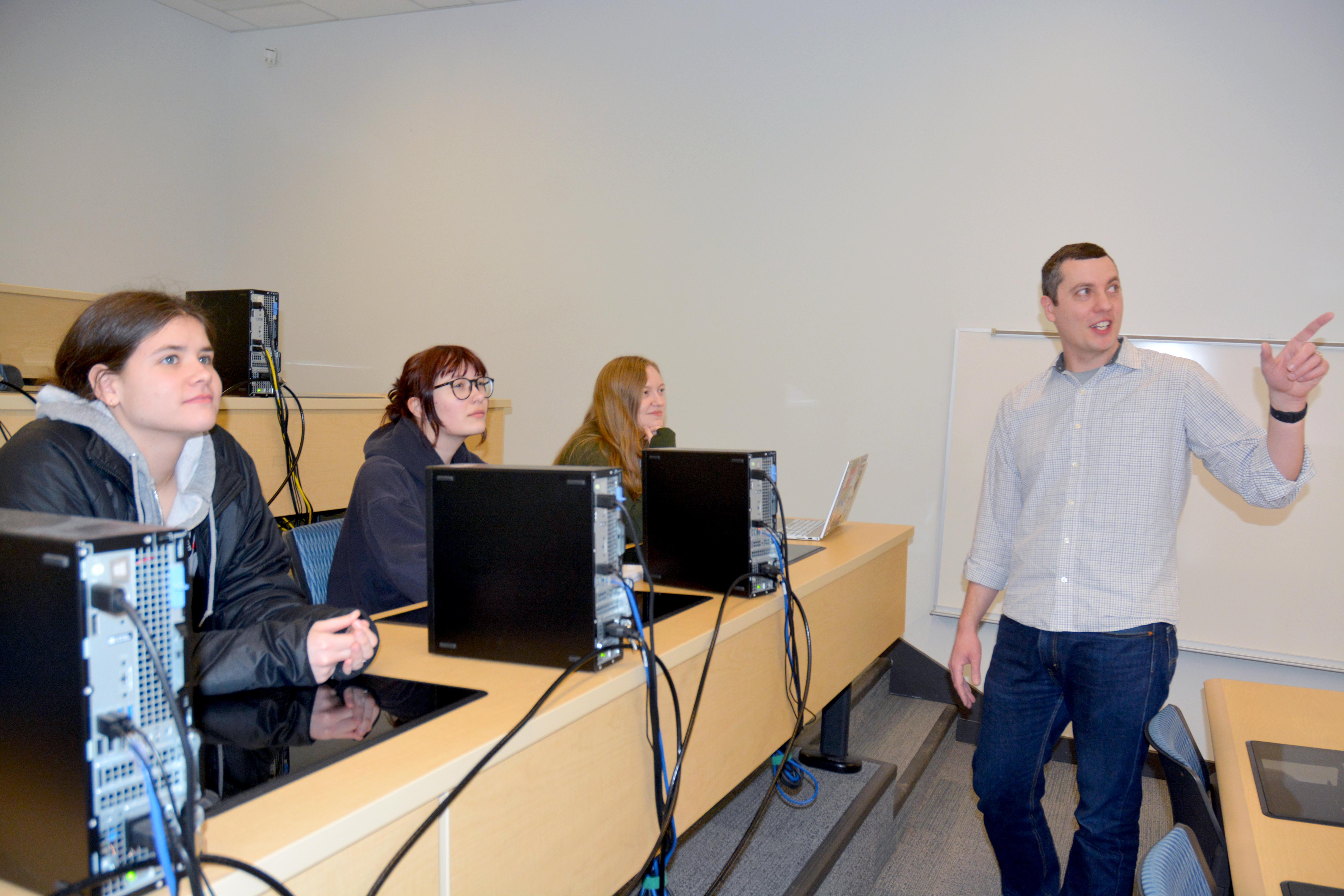 Faculty member Mark Baker speaks with students in a statistics class