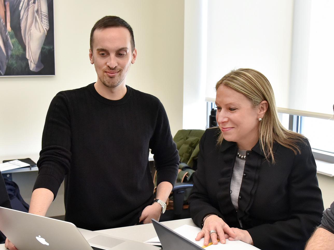 Michelle Storie and Marcus Lombardo review projects on a computer