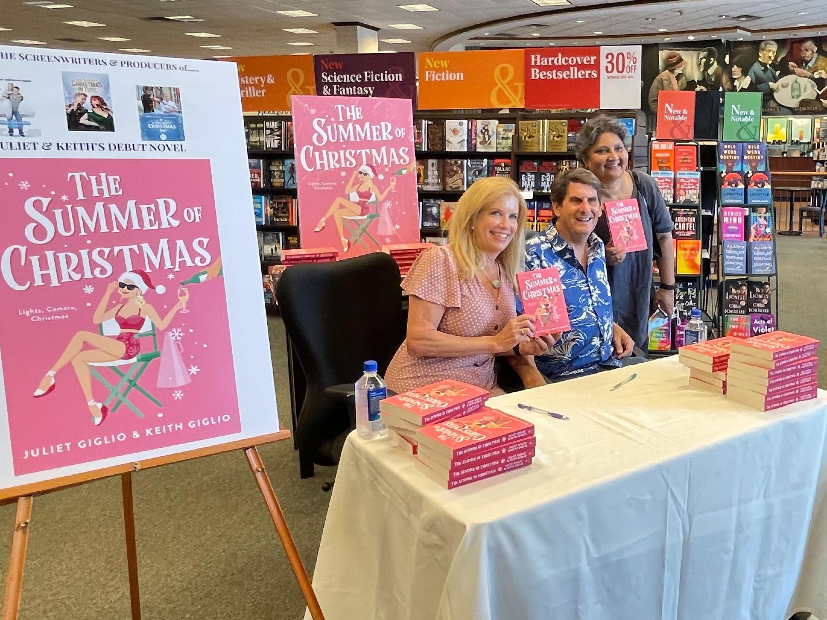 SUNY Oswego faculty member Juliet Giglio and her husband Keith, a Syracuse University faculty member, teamed up to write a new novel, "The Summer of Christmas"; here they participate in a book signing