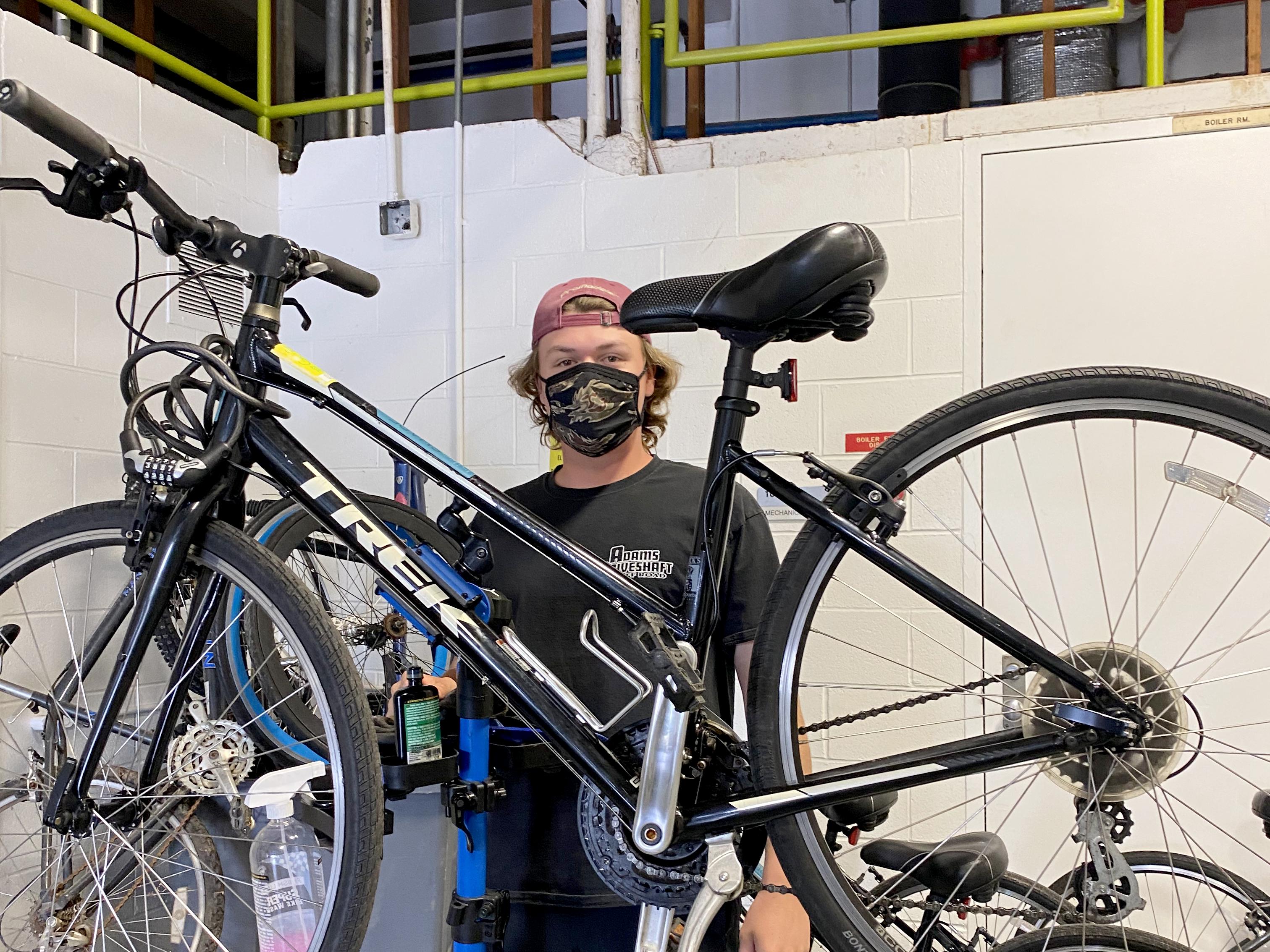 A student coordinator stands with one of the bicycles available in the Bike Share program