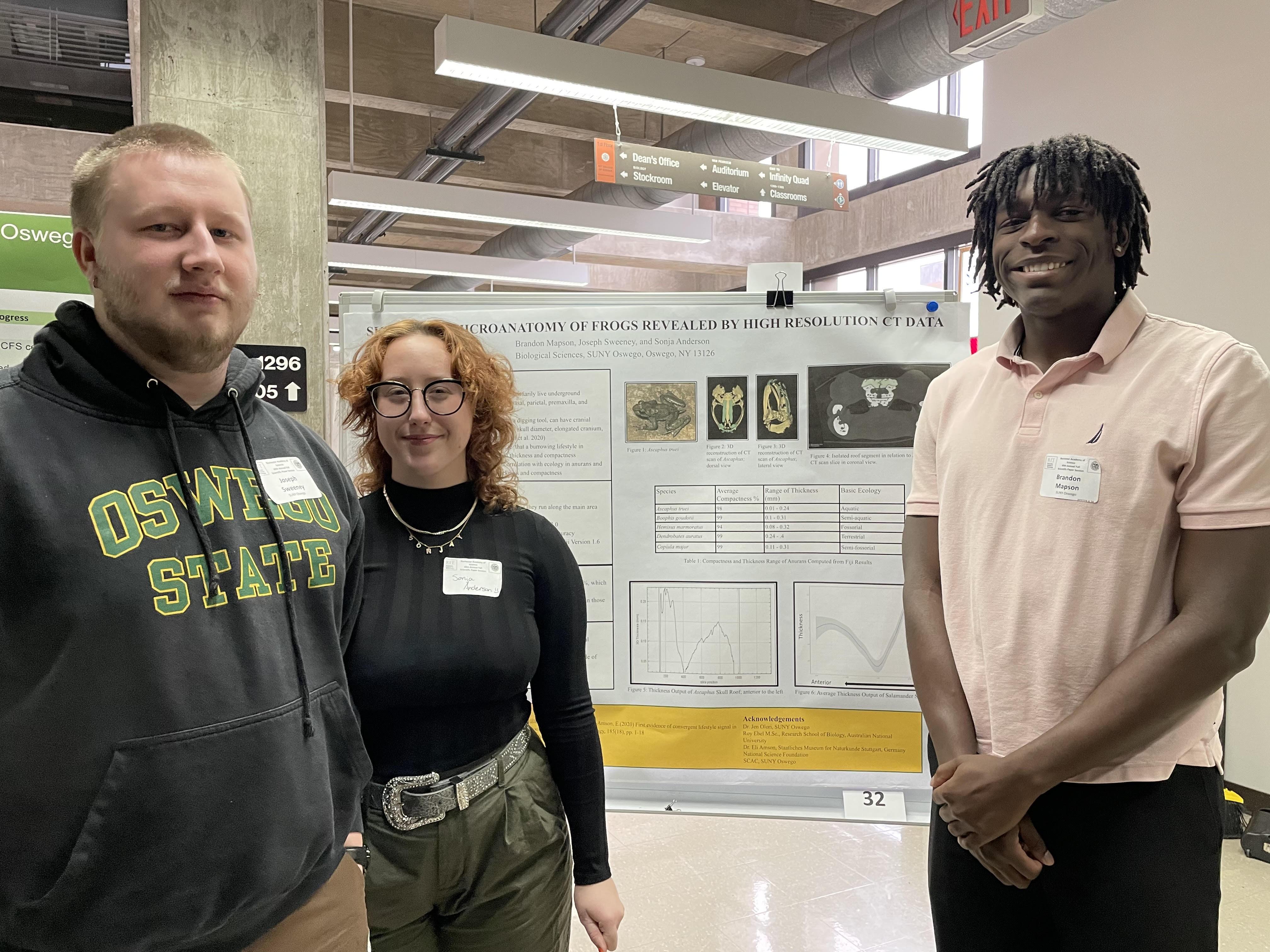 Three SUNY Oswego students presenting a poster
