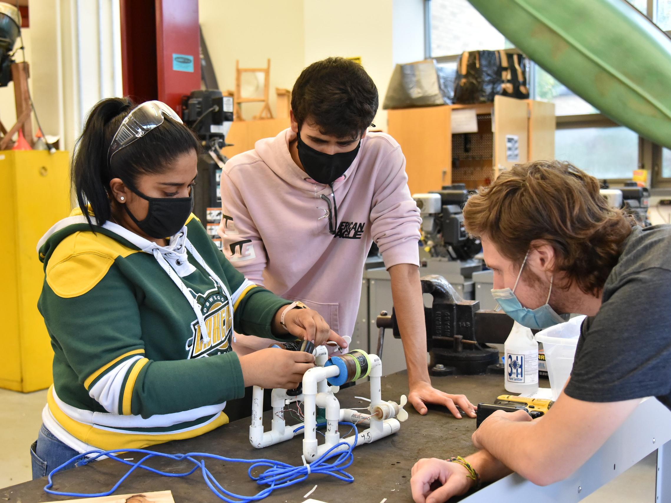 Three students work in a SUNY Oswego energy technology laboratory in Wilber Hall