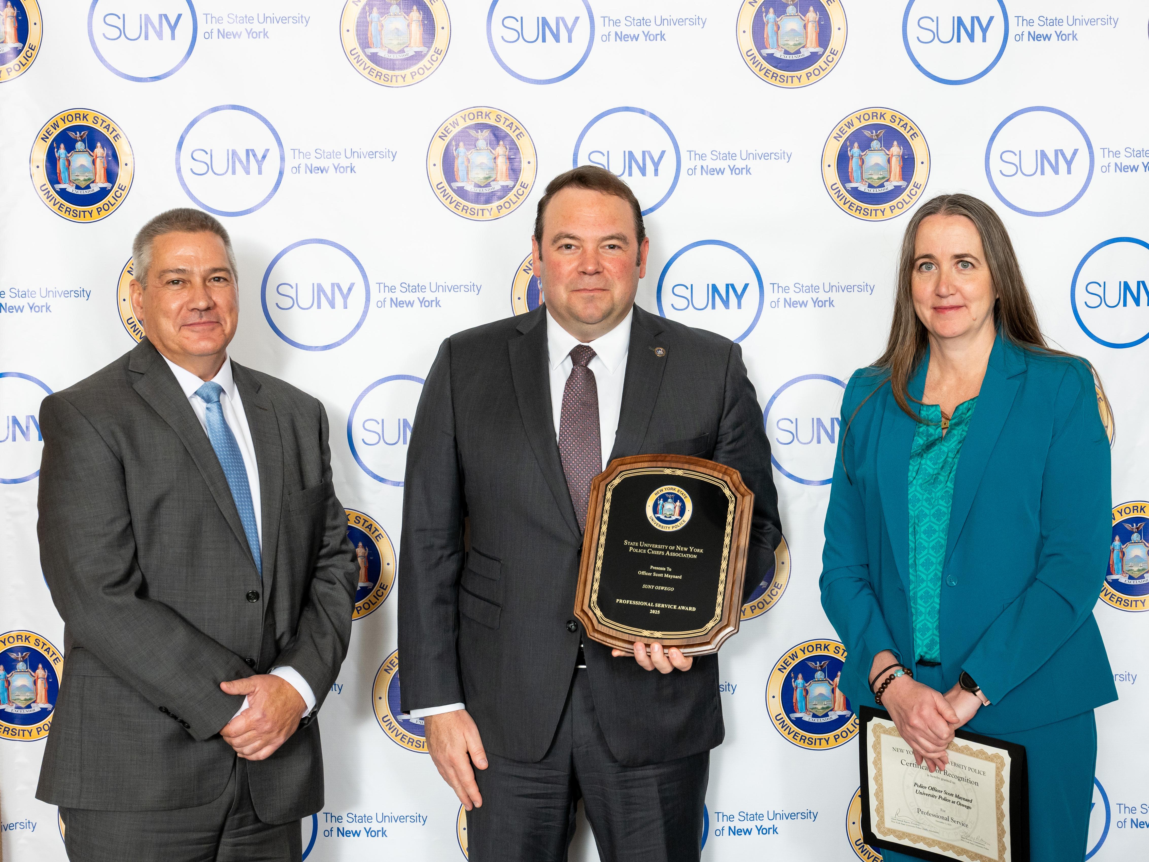 SUNY Oswego University Police Chief Scott Swayze accepts a SUNY award on behalf of Officer Scott Maynard