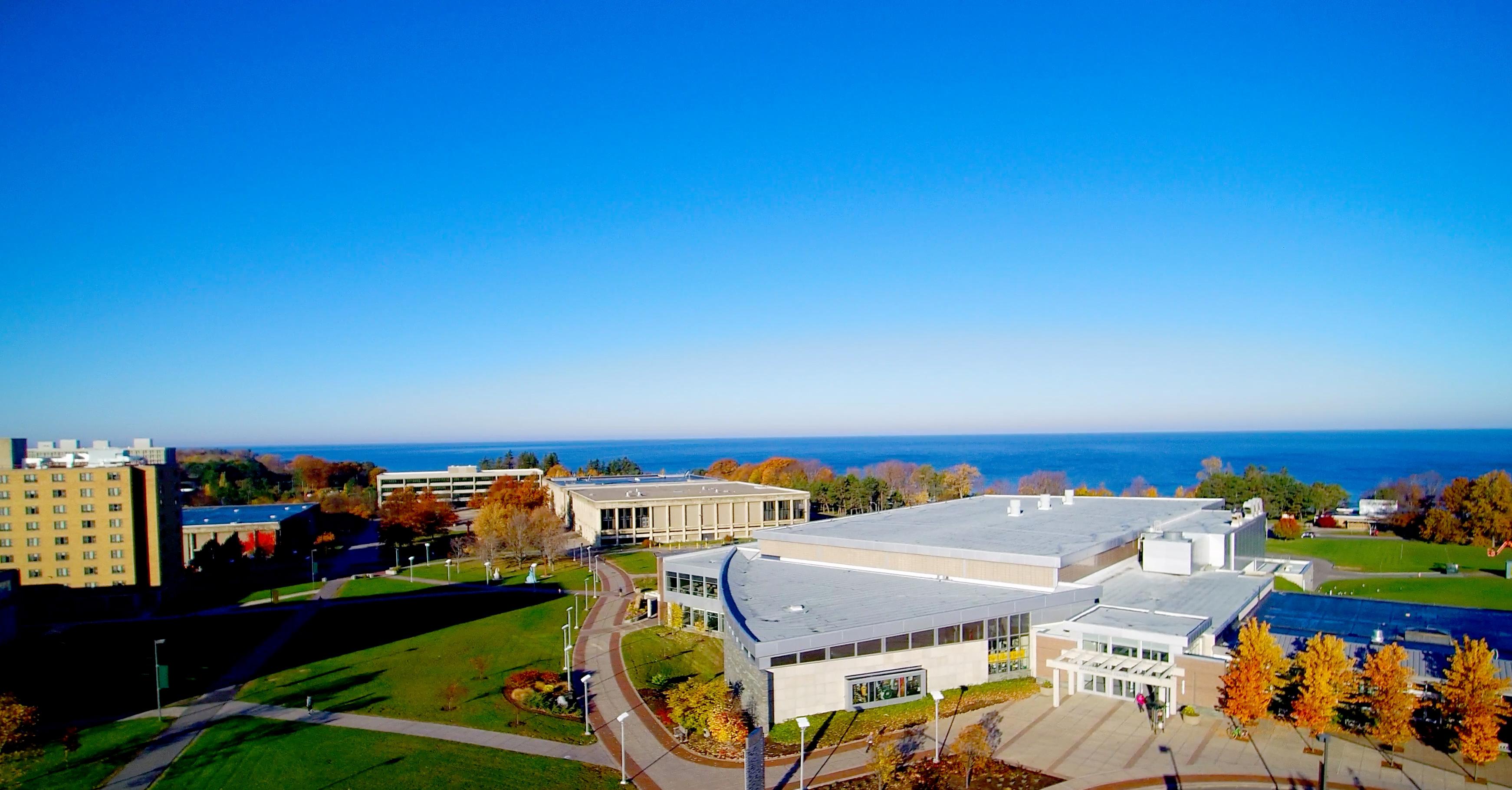 Aerial view of campus with fall foliage and Lake Ontario