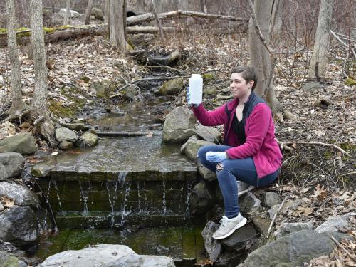 SUNY Oswego senior zoology major Jamie Perrin collects environmental DNA from recent winter melt