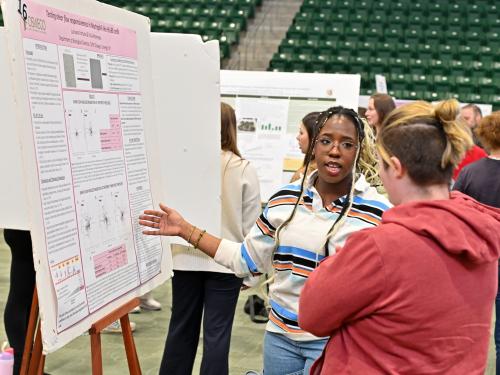 Biological sciences student Juziyana Fortuna talks about her "Testing shear flow responsiveness in Neutrophil-like HL-60 cells" during the April 23 Quest poster presentation session in the Deborah F. Stanley Arena and Convocation Hall.