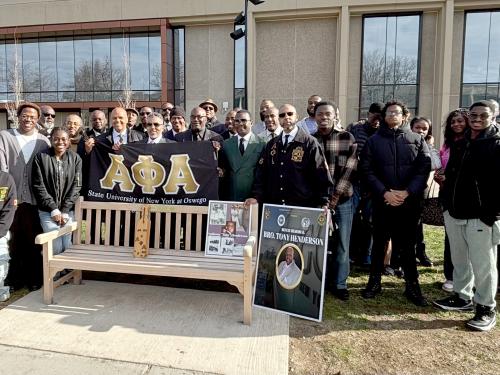 Members of Alpha Phi Alpha and the African Student Organization gather for the dedication of a bench to longtime residence hall director and mentor Tony Henderson