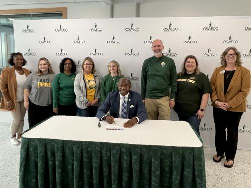 President Peter O. Nwosu, joined by members of SUNY Oswego's Campus Health and Well-being Committee, makes SUNY Oswego's participation the Okanagan Charter official with a charter signing on Friday, Sept. 26.