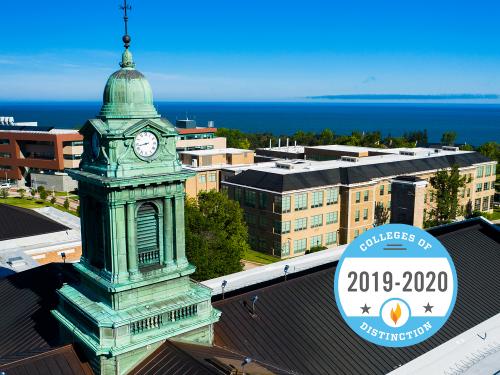 Aerial evening view of Sheldon Hall cupola with Colleges of Distinction logo