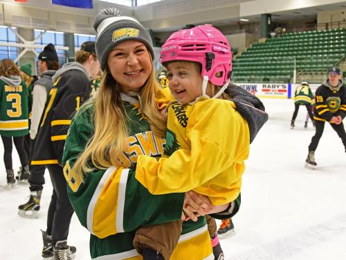Laker women's hockey player Taylor Hudon with a young fan at the annual Holiday Skate with the Lakers