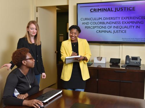 Criminal justice faculty member listening to student presentations