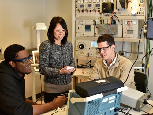  ECE faculty member Hui Zhang (standing), works with students (from left) Chibuike Ogbonna and Avery Croucher in spring 2022, after earning National Science Foundation funding for research related to improving the charging of electric vehicles.