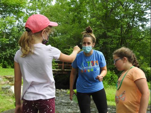 A child participating in Exploring Nature shows a finding to her teacher