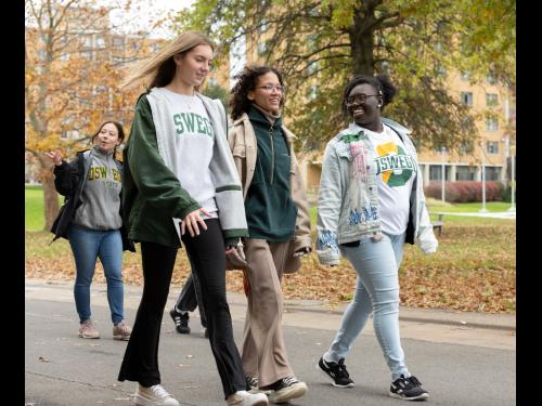 Students walk across campus on a fall day