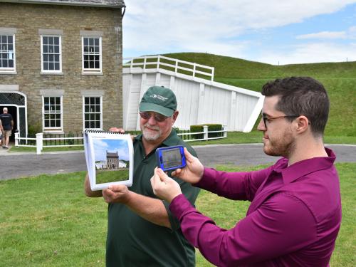 Fort Ontario's Paul Lear and SUNY Oswego graduate student Theo Johnson demonstrate an app that uses historical photos as reference points