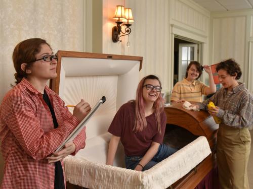 Cast photo of actors playing children filming a funeral home ad