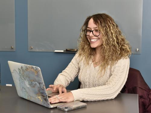 Gabrielle Golfo works on her laptop in the Educational Opportunity Program office