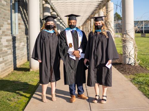 Three students outside Marano Campus Center for Commencement