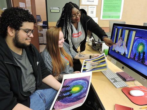 Students look at artwork submitted by schoolchildren