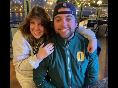 Annie and Ryan at restaurant in SUNY Oswego gear