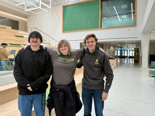 Three SUNY Oswego students pose in Hewitt Hall after placing in the 2026 BEA Awards